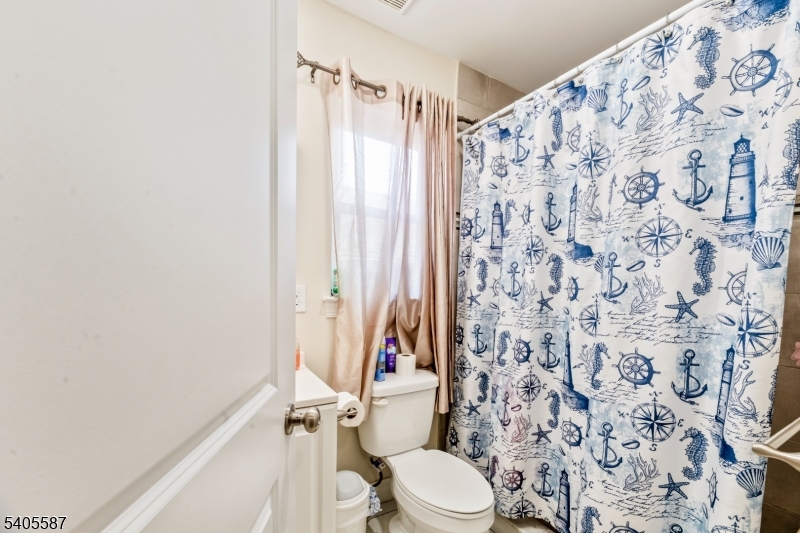 14 Spencer Street Elizabeth, NJ 07202 - Photo 27 of 39 a white toilet sitting next to a shower curtain