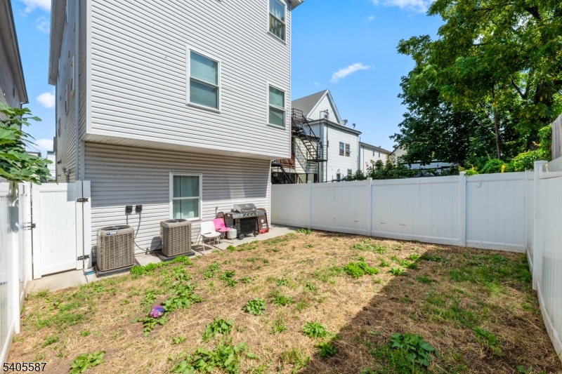 14 Spencer Street Elizabeth, NJ 07202 - Photo 35 of 39 a backyard of a house with large trees and plants