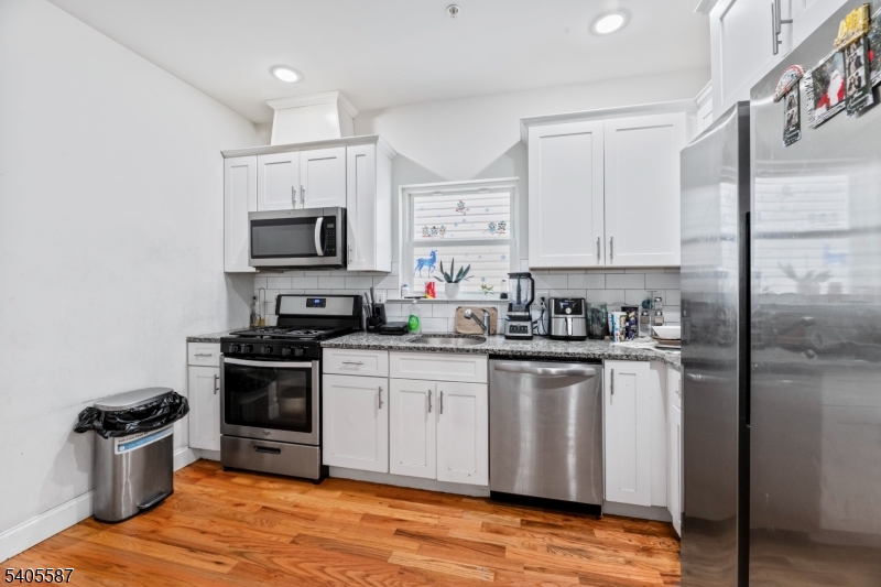 14 Spencer Street Elizabeth, NJ 07202 - Photo 8 of 39 a kitchen with stainless steel appliances granite countertop a stove a sink dishwasher and a refrigerator