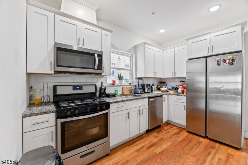 14 Spencer Street Elizabeth, NJ 07202 - Photo 9 of 39 a kitchen with cabinets stainless steel appliances and a window