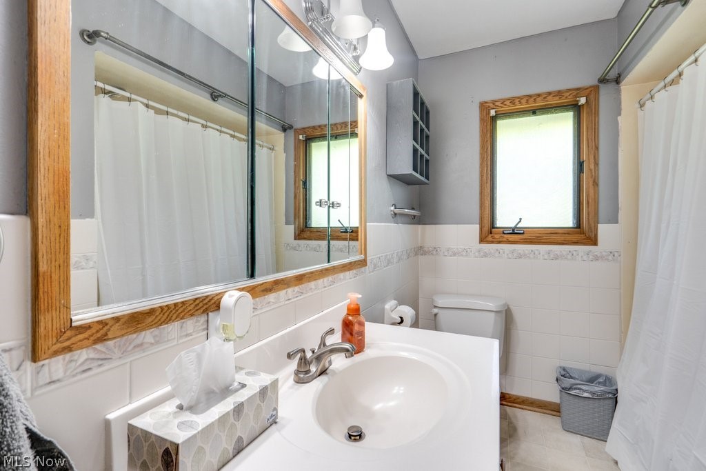 426 Heimbaugh Road Mogadore, OH 44260 - Photo 9 of 26 Bathroom featuring tile walls, a healthy amount of sunlight, tile flooring, and toilet