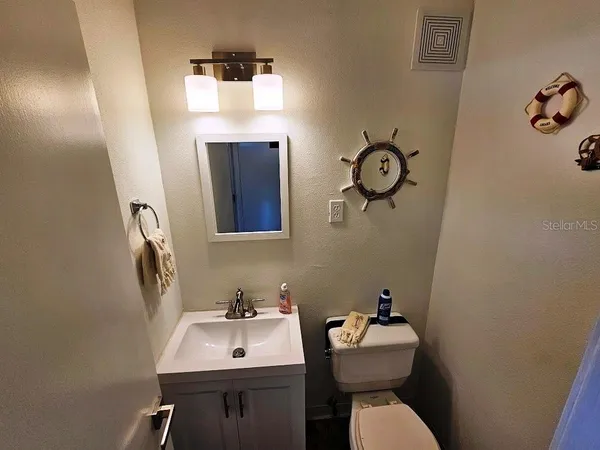 a bathroom with a sink mirror and toilet
