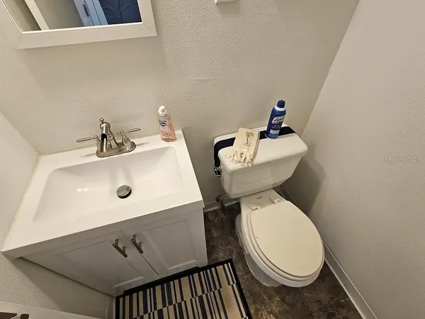 a bathroom with a sink toilet and mirror