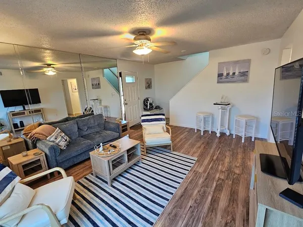 a living room with furniture a flat screen tv and kitchen view