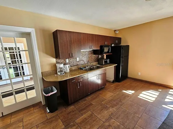 a kitchen with stainless steel appliances granite countertop a sink and a refrigerator