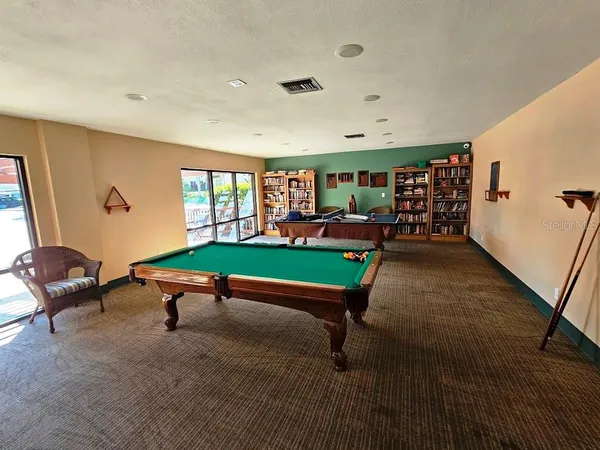 a room with furniture pool table and windows