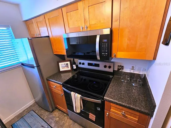 a kitchen with stainless steel appliances granite countertop a stove a sink and a microwave