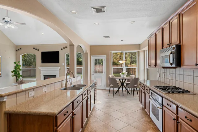 a dining hall with stainless steel appliances granite countertop a stove and a sink