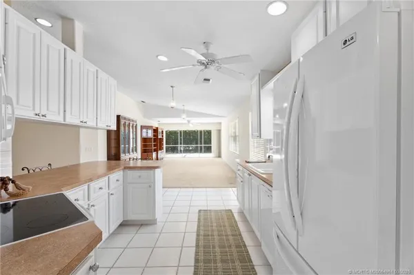 a kitchen with granite countertop a stove a sink and a refrigerator
