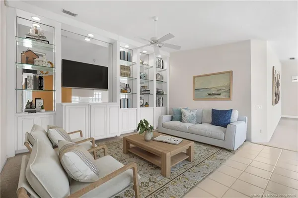 a living room with furniture a flat screen tv and kitchen view
