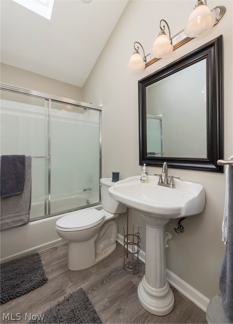 13175 McCracken Road Cleveland, OH 44125 - Photo 23 of 48 Bathroom featuring a skylight, toilet, and enclosed tub / shower combo