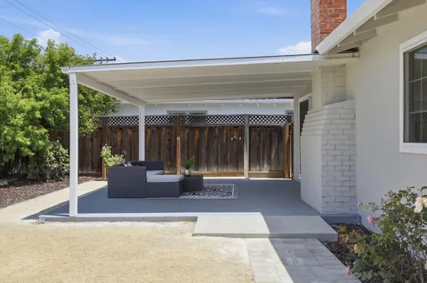 a view of house with backyard and glass windows