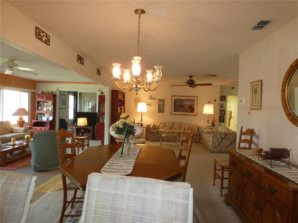 11151 Sandtrap Drive, Unit 11151 Port Richey, FL 34668 - Photo 17 of 33 a living room with lots of furniture and chandelier