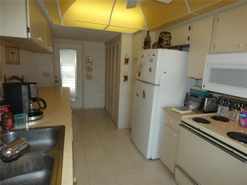 11151 Sandtrap Drive, Unit 11151 Port Richey, FL 34668 - Photo 19 of 33 a kitchen with stainless steel appliances granite countertop a refrigerator and a stove