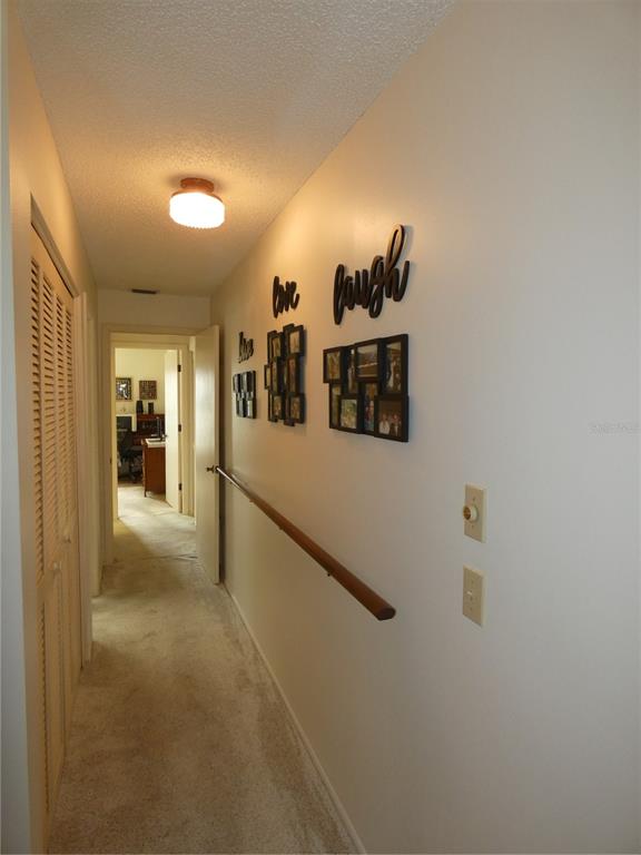 11151 Sandtrap Drive, Unit 11151 Port Richey, FL 34668 - Photo 23 of 33 a view of a hallway with a white cabinet and a refrigerator