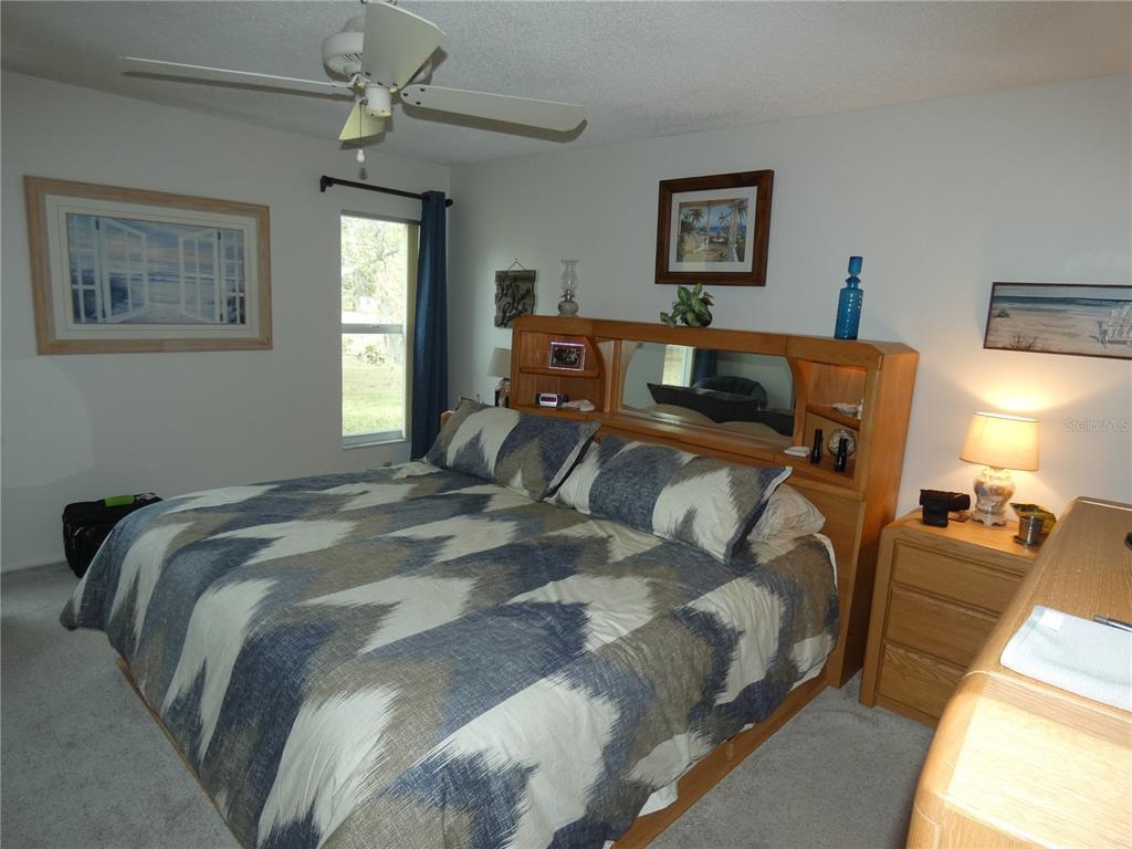 11151 Sandtrap Drive, Unit 11151 Port Richey, FL 34668 - Photo 25 of 33 a bedroom with a bed and wooden floor