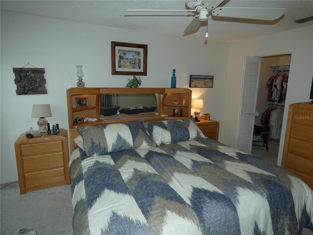 11151 Sandtrap Drive, Unit 11151 Port Richey, FL 34668 - Photo 26 of 33 a bedroom with a bed and furniture