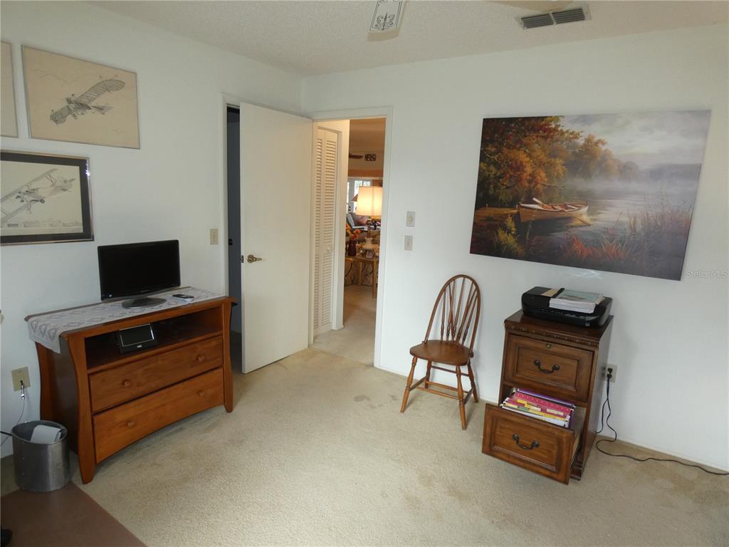 11151 Sandtrap Drive, Unit 11151 Port Richey, FL 34668 - Photo 30 of 33 a living room with furniture and a flat screen tv