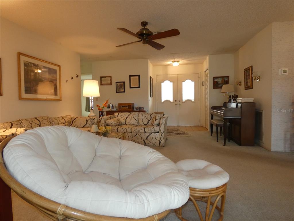 11151 Sandtrap Drive, Unit 11151 Port Richey, FL 34668 - Photo 8 of 33 a living room with furniture and a chandelier
