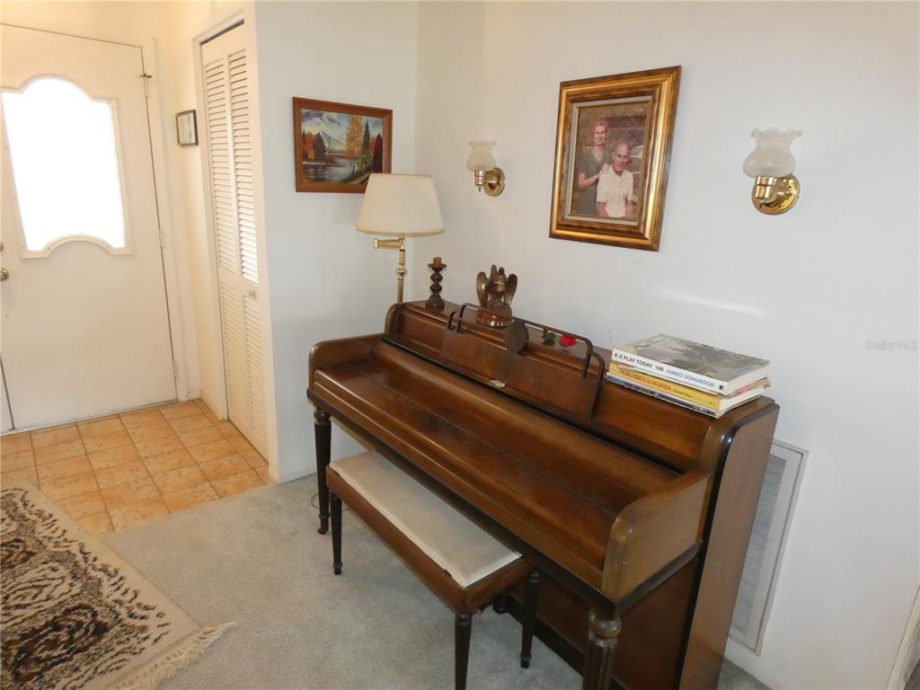 11151 Sandtrap Drive, Unit 11151 Port Richey, FL 34668 - Photo 9 of 33 a living room with a bed and a dresser next to a window