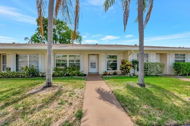 front view of a house with yard and an trees