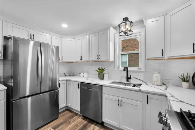 a kitchen with stainless steel appliances a refrigerator sink and cabinets