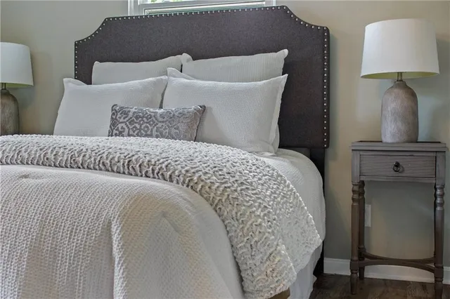 a bed sitting in a bedroom next to a lamp