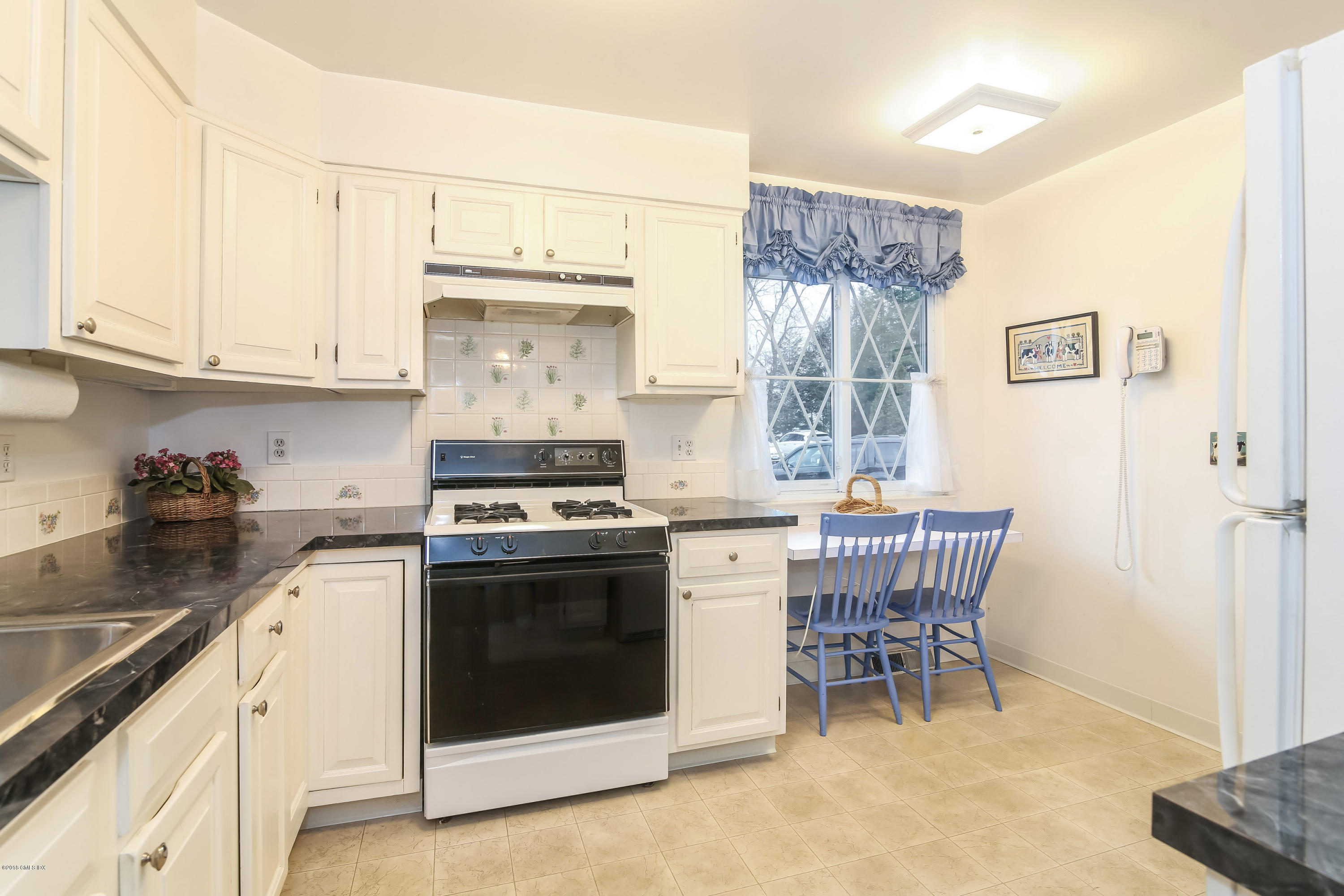 37 Sheep Hill Road, Unit 6 Riverside, CT 06878 - Photo 5 of 18 a kitchen with a stove a sink and chairs
