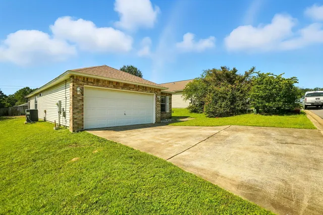 a view of yellow house with a yard and garage