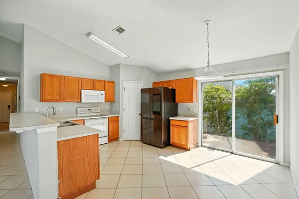 a kitchen with a refrigerator a stove top oven a sink dishwasher and cabinets