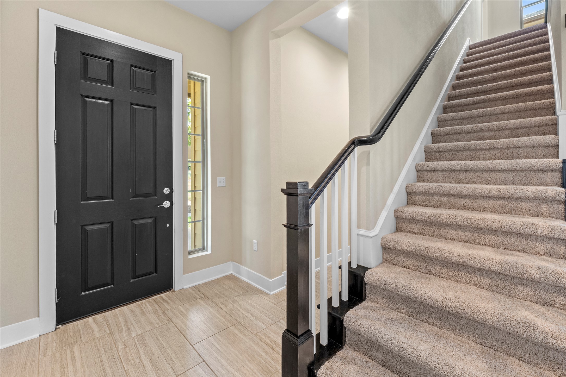 1709 Lawrence Street, Unit 5 Austin, TX 78741 - Photo 16 of 40 Tiled entryway leads directly to carpeted stairs framed by a classic wooden handrail.