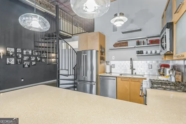 a kitchen with stainless steel appliances granite countertop a refrigerator a stove a sink dishwasher and a cabinets with wooden floor