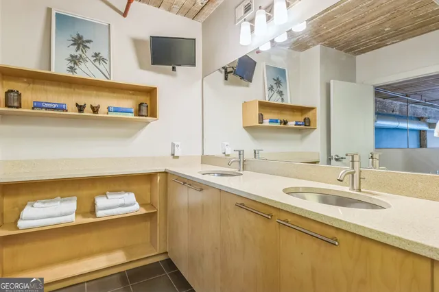 a spacious bathroom with a granite countertop sink a toilet a mirror and shower