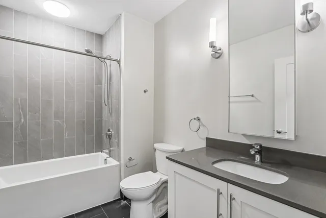 a bathroom with a granite countertop sink toilet and shower