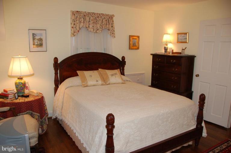 9507 Bruce Drive Silver Spring, MD 20901 - Photo 12 of 16 a bedroom with a bed and a lamp on dresser