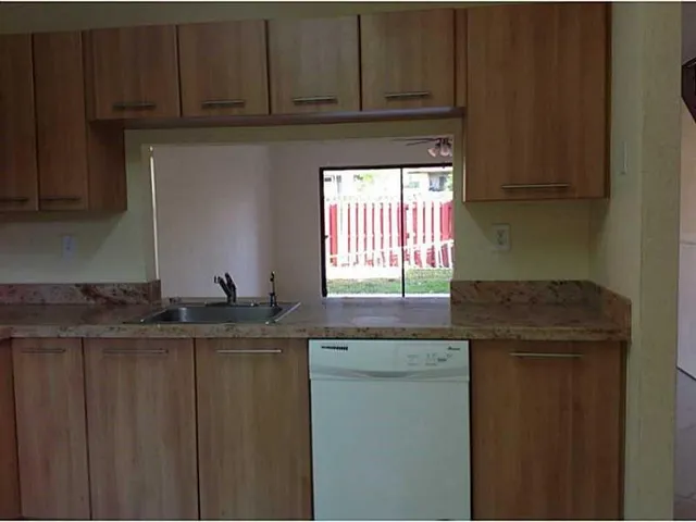 a kitchen with granite countertop cabinets and window