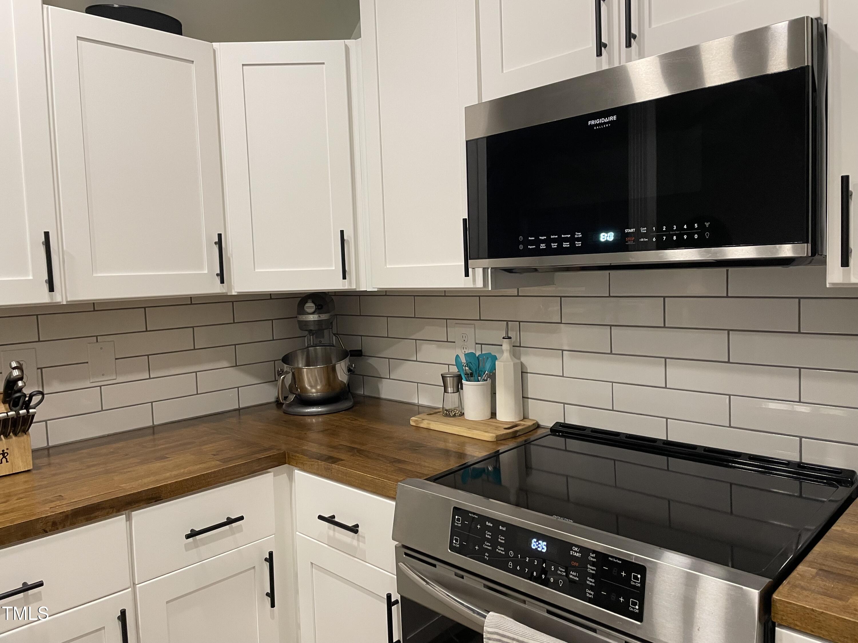 2036 Metacomet Way Raleigh, NC 27604 - Photo 6 of 21 a kitchen with stainless steel appliances a stove a microwave a sink and cabinets
