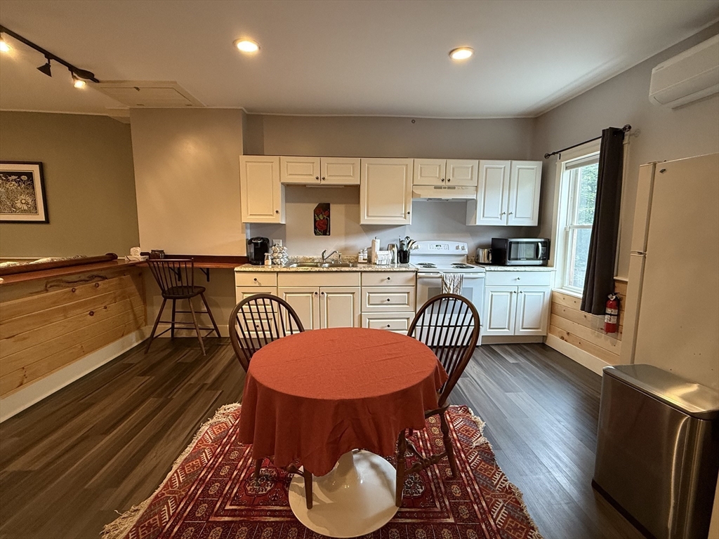 5 Bridge Street Montague, MA 01349 - Photo 3 of 36 a kitchen with stainless steel appliances granite countertop a dining table chairs stove a sink and dishwasher a refrigerator with wooden floor
