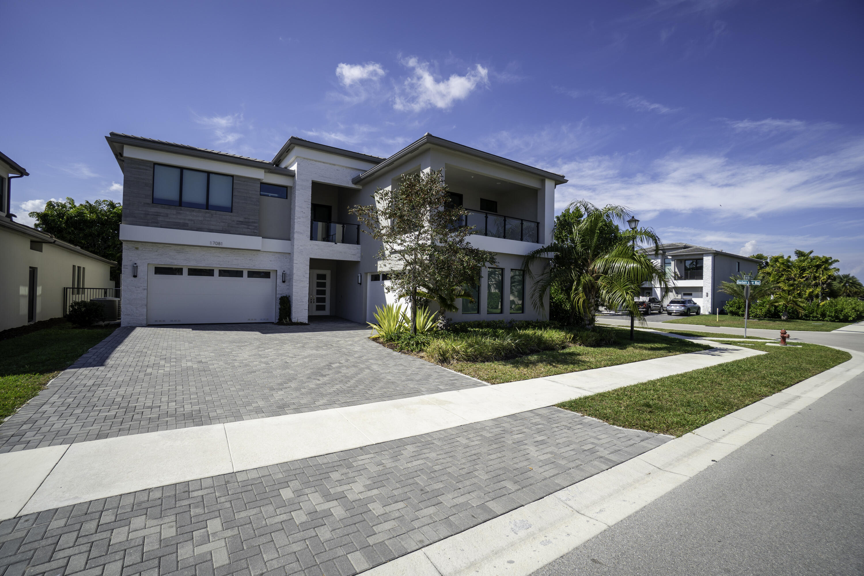 17081 Five Waters Avenue Boca Raton, FL 33496 - Photo 14 of 109 a front view of a house with yard and a garage