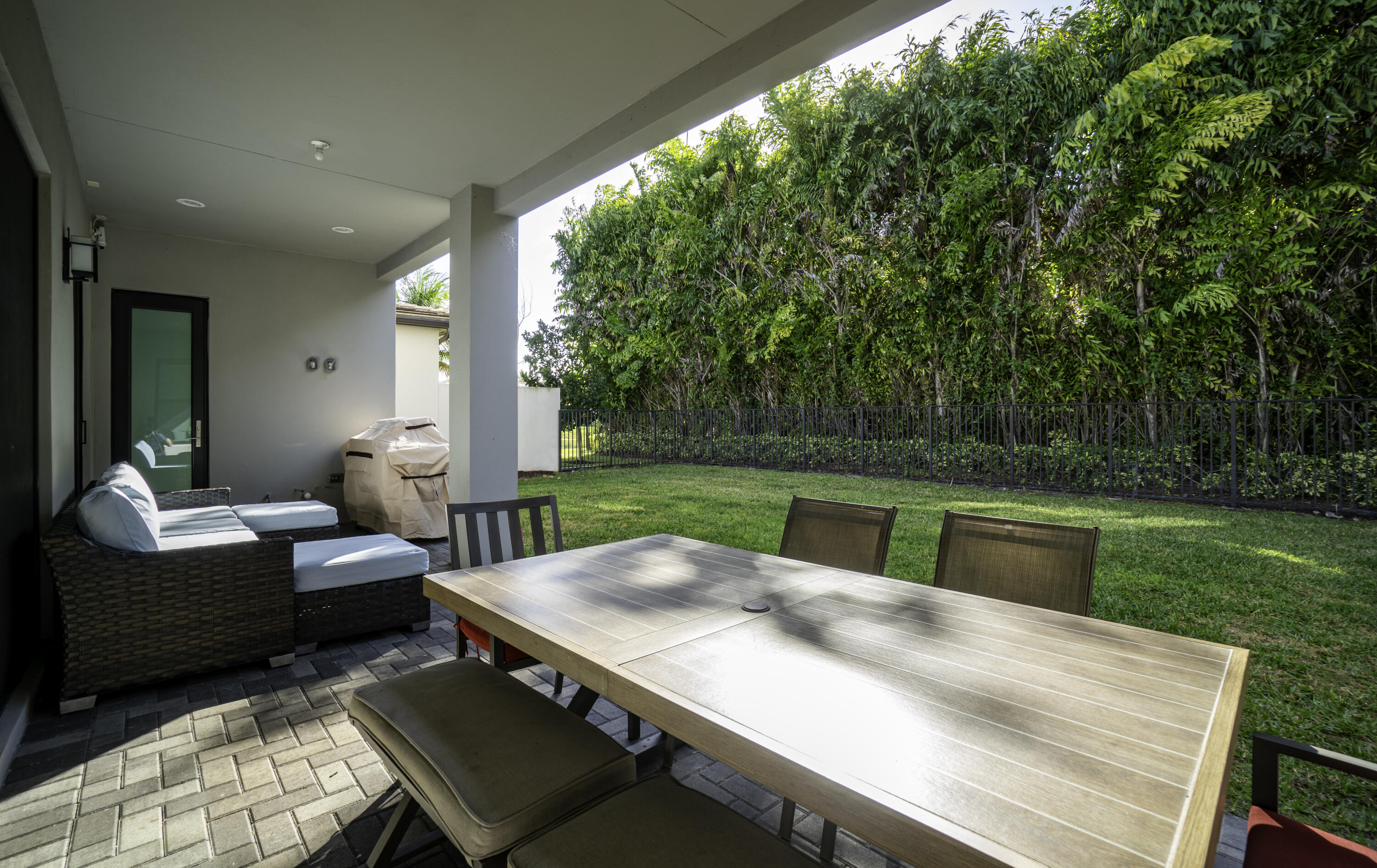 17081 Five Waters Avenue Boca Raton, FL 33496 - Photo 16 of 109 a view of a patio with couches chairs and a yard