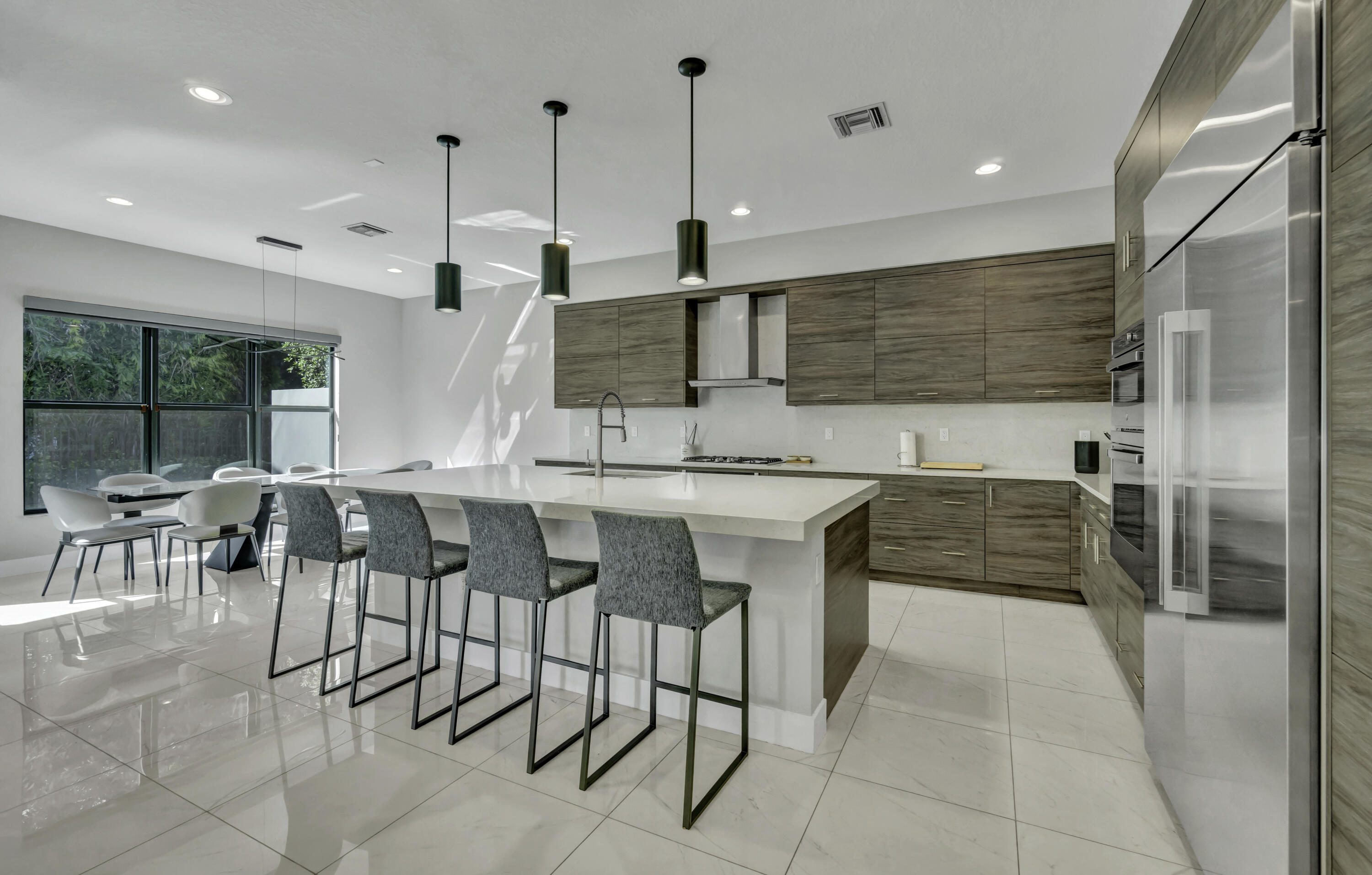 17081 Five Waters Avenue Boca Raton, FL 33496 - Photo 29 of 109 a kitchen with stainless steel appliances kitchen island granite countertop a sink and cabinets