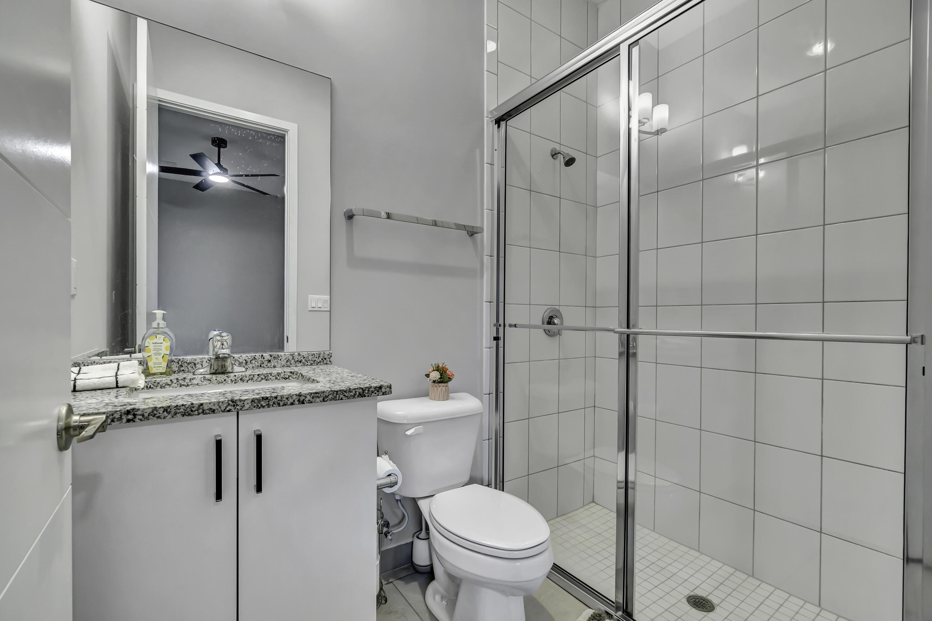 17081 Five Waters Avenue Boca Raton, FL 33496 - Photo 44 of 109 a bathroom with a granite countertop sink a toilet and shower