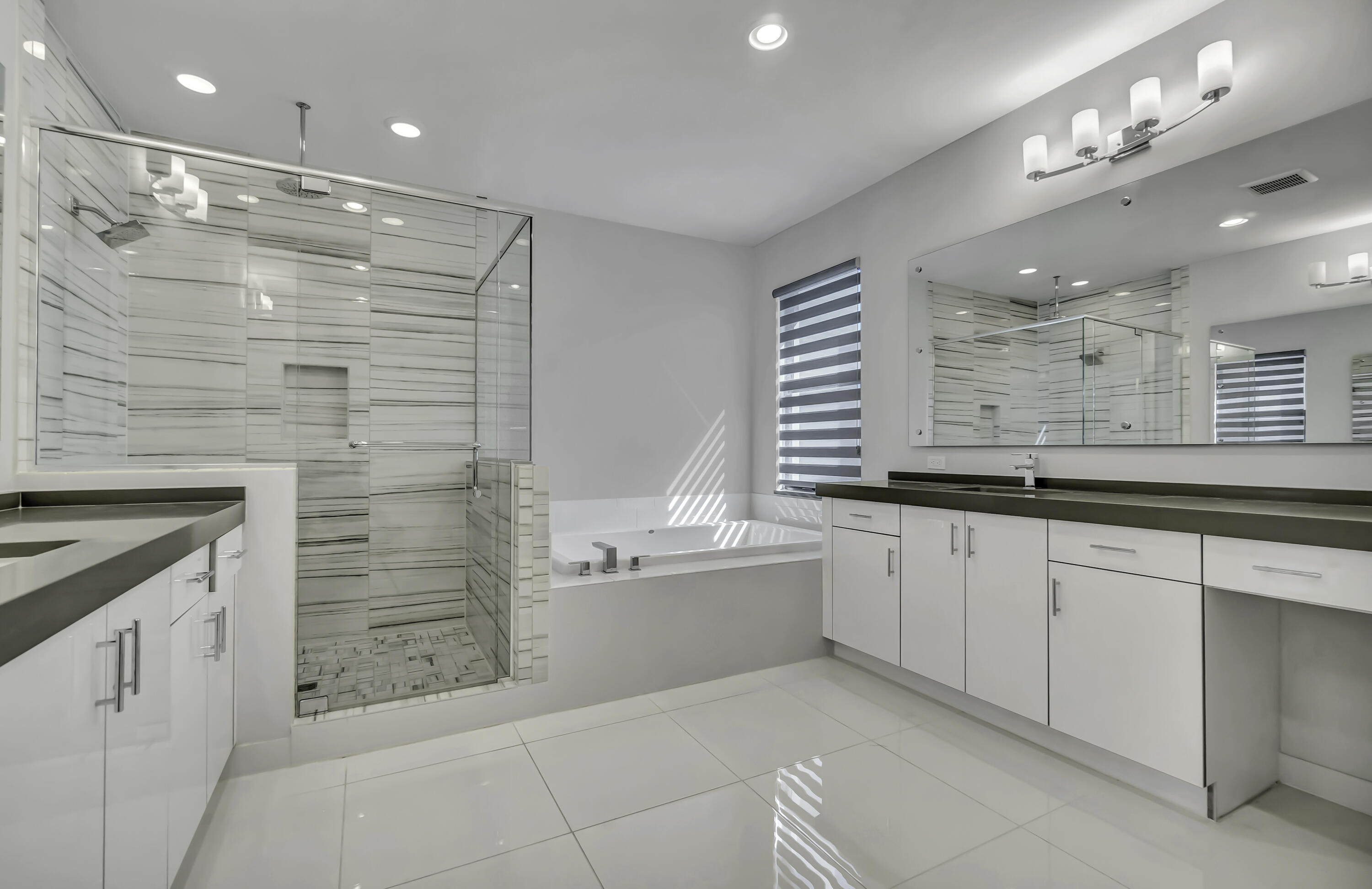 17081 Five Waters Avenue Boca Raton, FL 33496 - Photo 57 of 109 a bathroom with a granite countertop sink mirror and a bathtub
