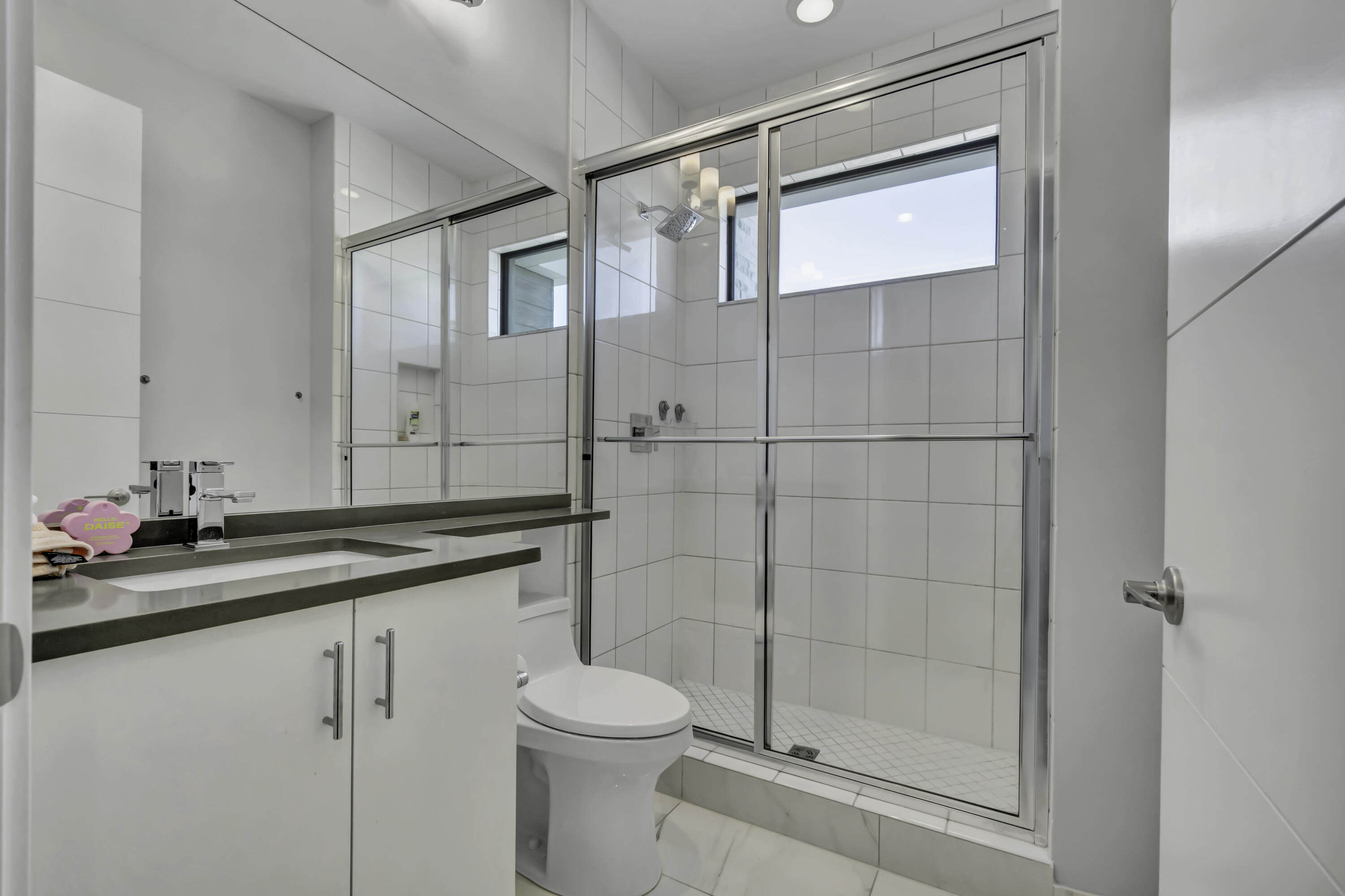 17081 Five Waters Avenue Boca Raton, FL 33496 - Photo 66 of 109 a bathroom with a shower sink vanity and toilet