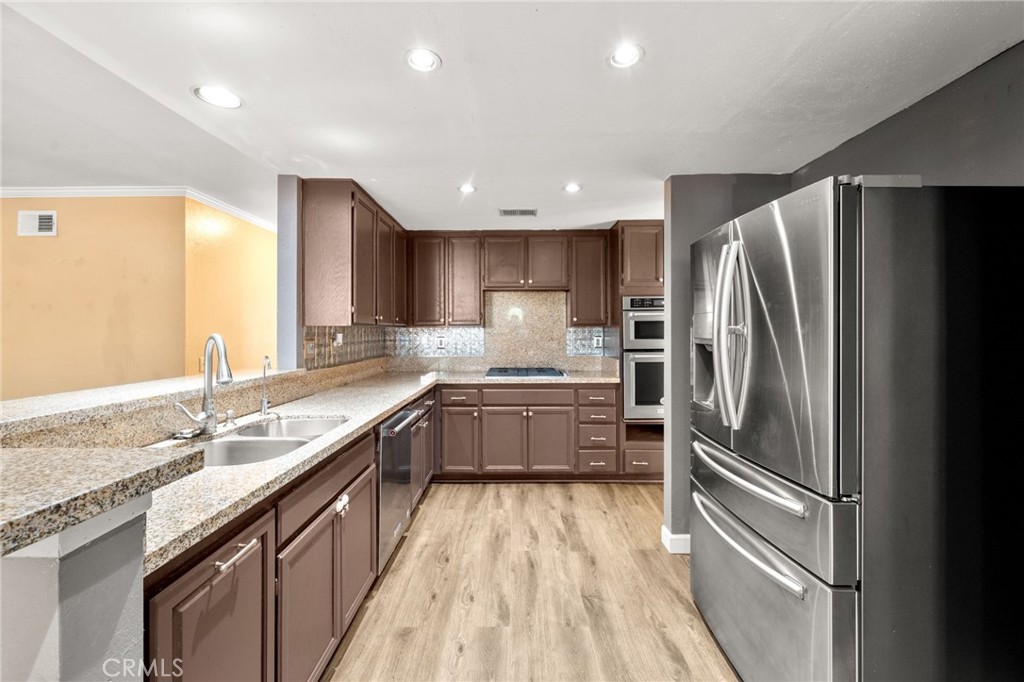 40219 Donomore Court Temecula, CA 92591 - Photo 15 of 63 a kitchen with stainless steel appliances granite countertop a refrigerator and a sink