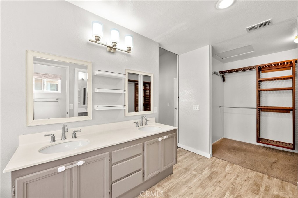 40219 Donomore Court Temecula, CA 92591 - Photo 33 of 63 a spacious bathroom with a double vanity sink a large mirror and a shower