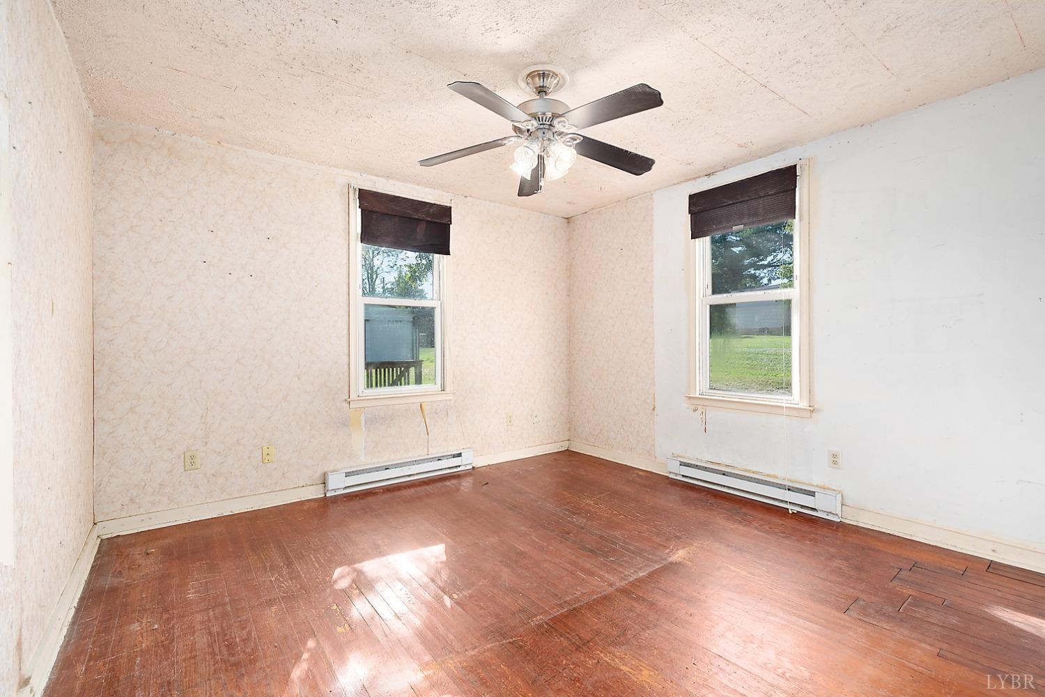 10435 Red House Road Appomattox, VA 24522 - Photo 24 of 32 an empty room with wooden floor chandelier fan and windows