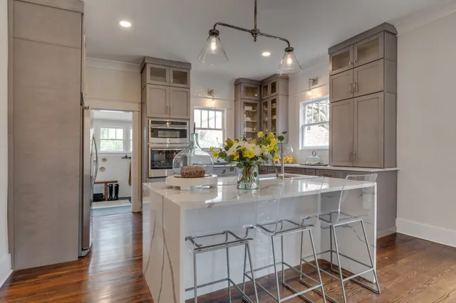 a kitchen with a chandelier appliances and a dining table