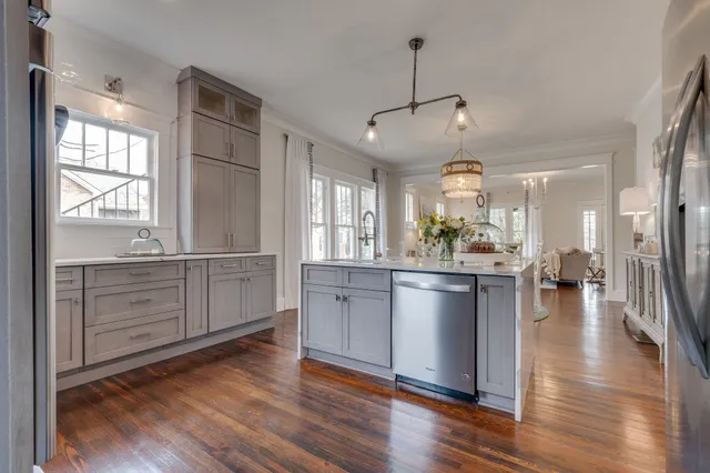 a kitchen with cabinets stainless steel appliances a sink and a window