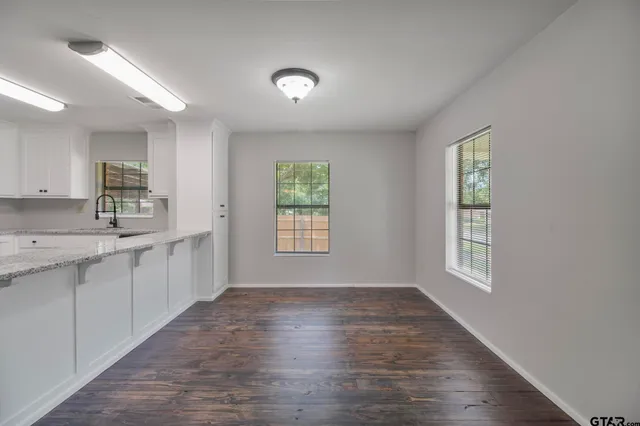 a view of a kitchen with a sink dishwasher and wooden floor